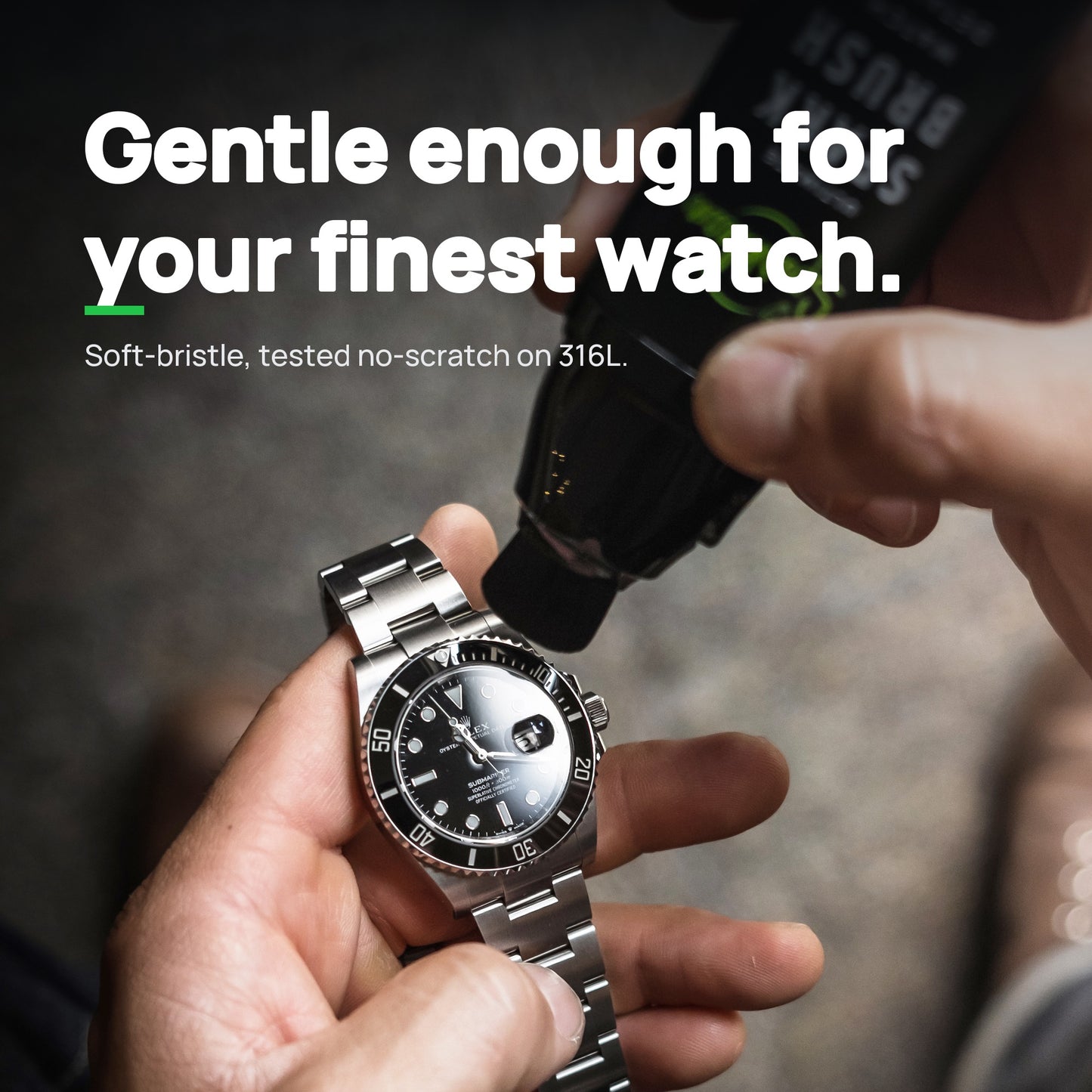 SparkBrush cleaning a stainless steel luxury dive watch held in hand